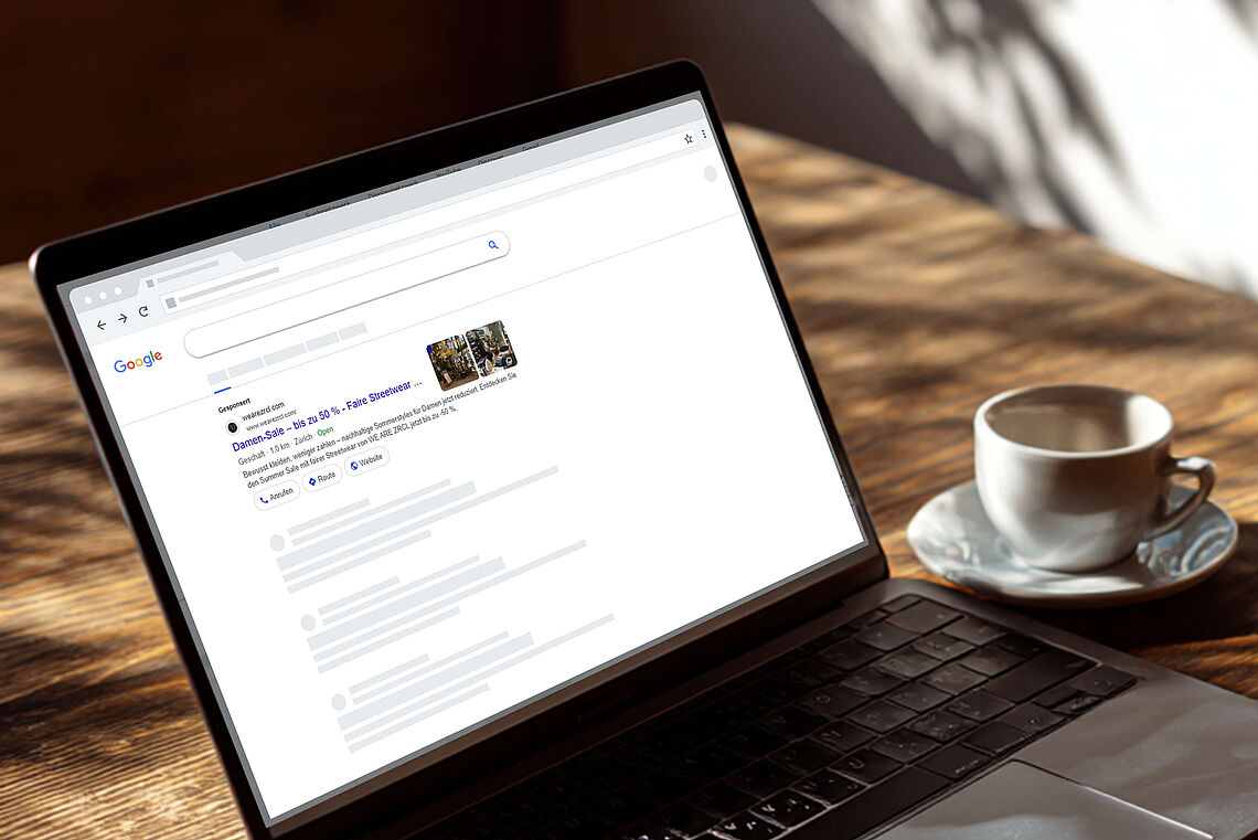 Ein geöffneter Laptop zeigt ein Google-Suchergebnis für den Damen-Sale von WE ARE ZRCL. Auf dem Bildschirm ist der Anzeigentext mit bis zu 50 % Rabatt auf nachhaltige Streetwear sichtbar.